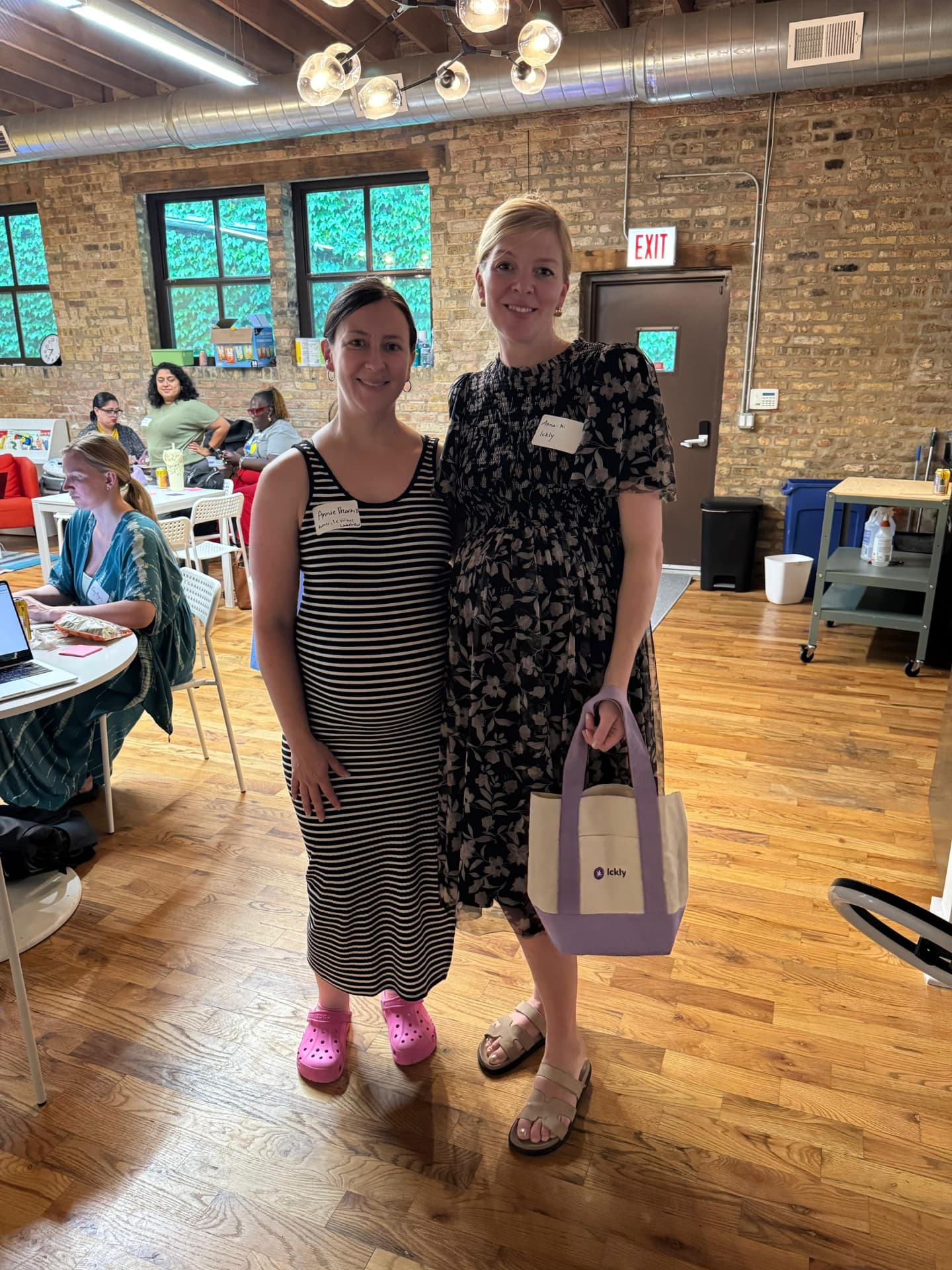 Two parents standing together, one holding an Ickly tote bag