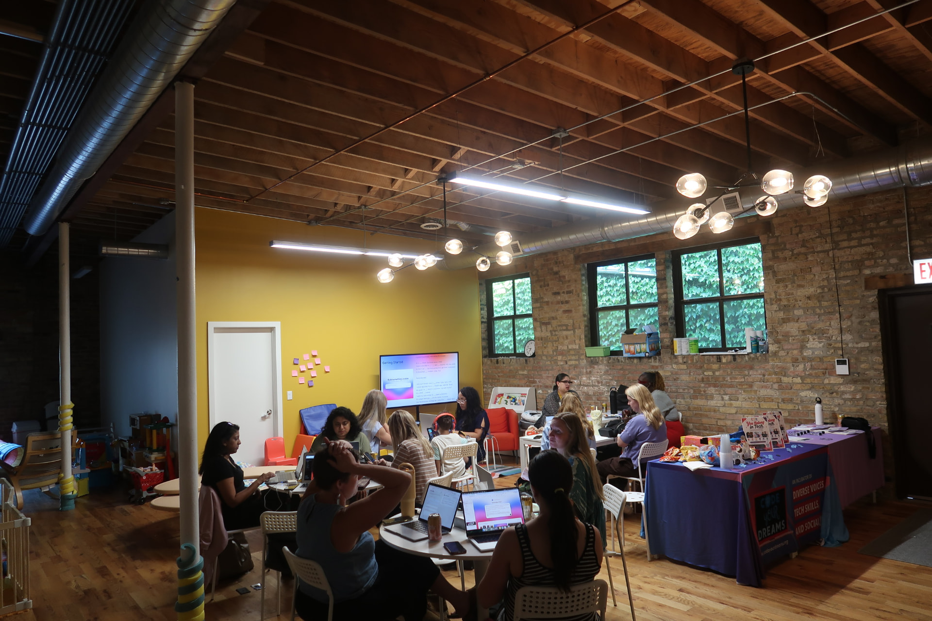Parents working on laptops together at a community meetup space