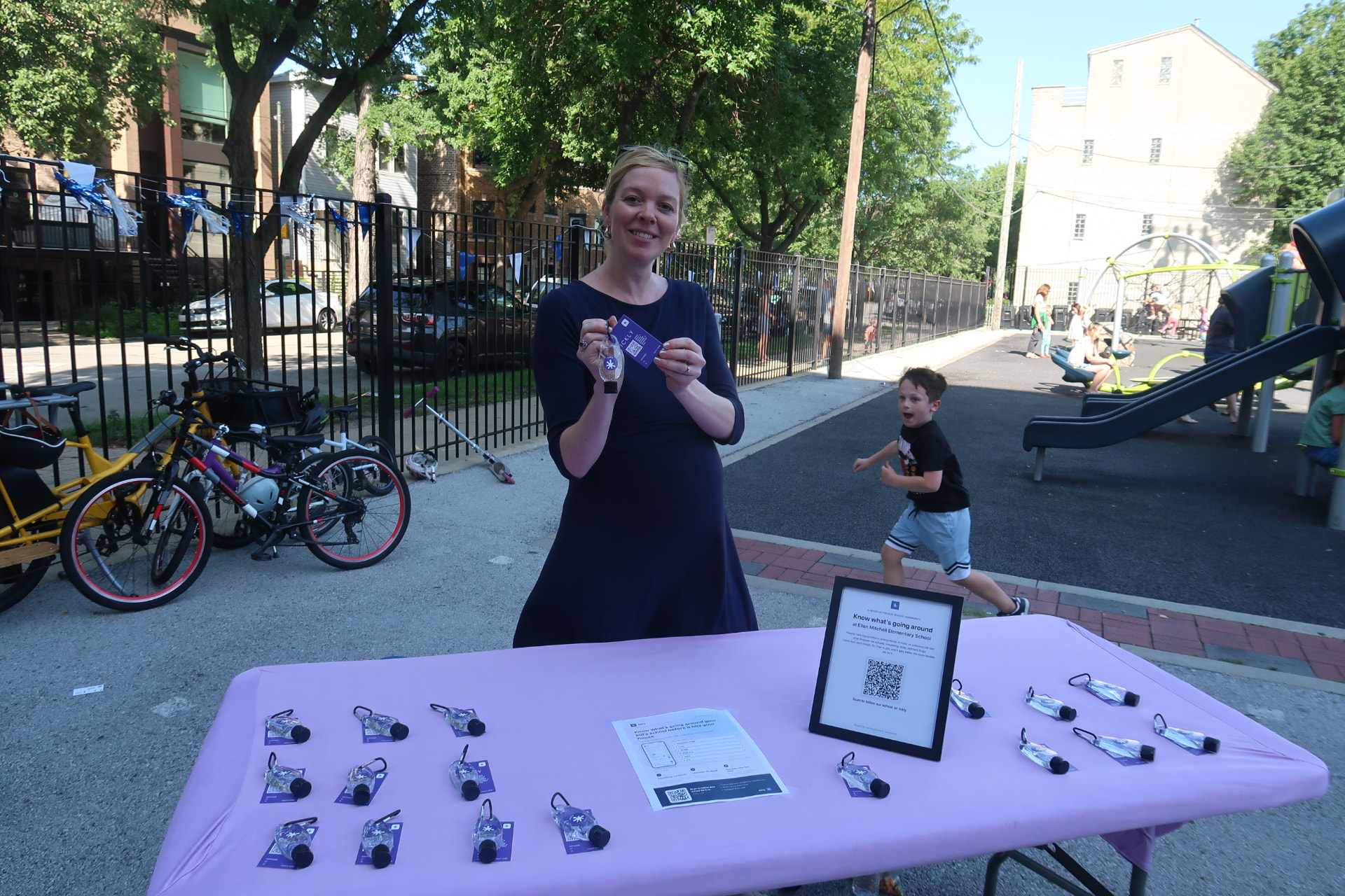 Ickly founder at a school event table with branded hand sanitizers, a flyer and a QR code sign